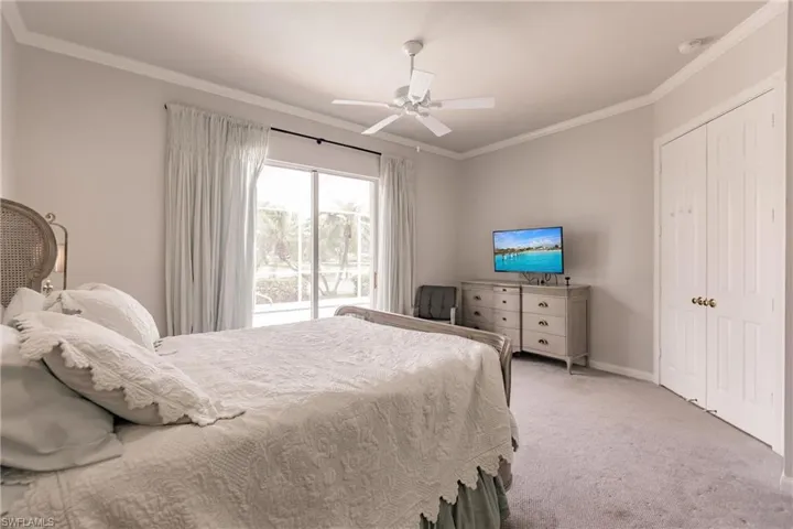 Bedroom featuring light carpet, a closet, access to exterior, ornamental molding, and ceiling fan