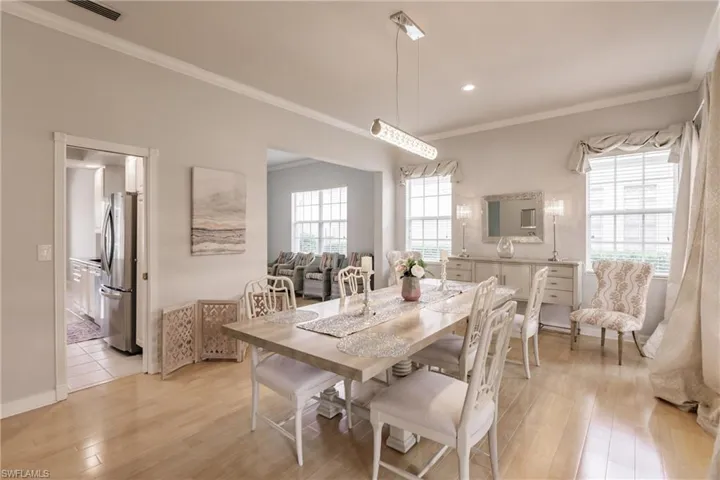 Dining room with crown molding and light hardwood / wood-style flooring