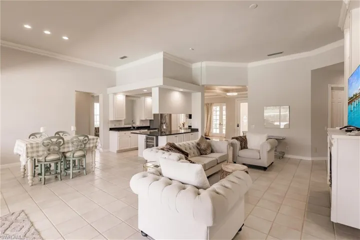 Tiled living room featuring crown molding and sink
