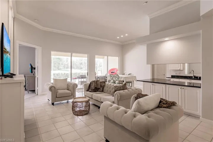 Tiled living room featuring crown molding and sink