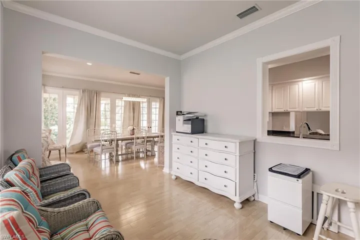 Living room with crown molding, sink, and light hardwood / wood-style floors