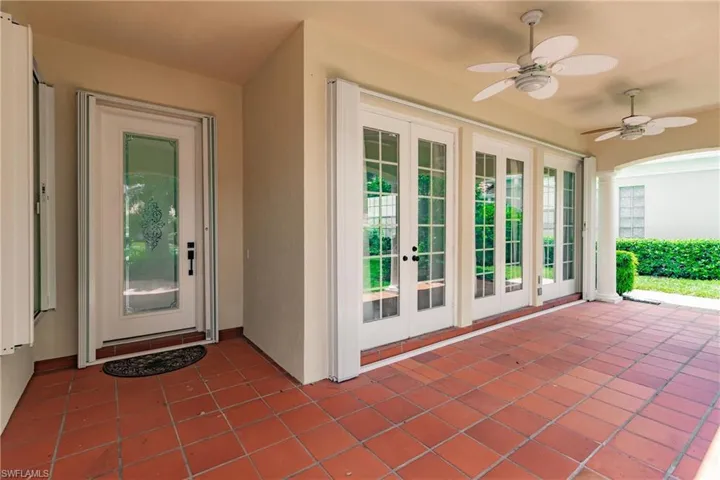 Entrance to property featuring ceiling fan, a patio area, and french doors
