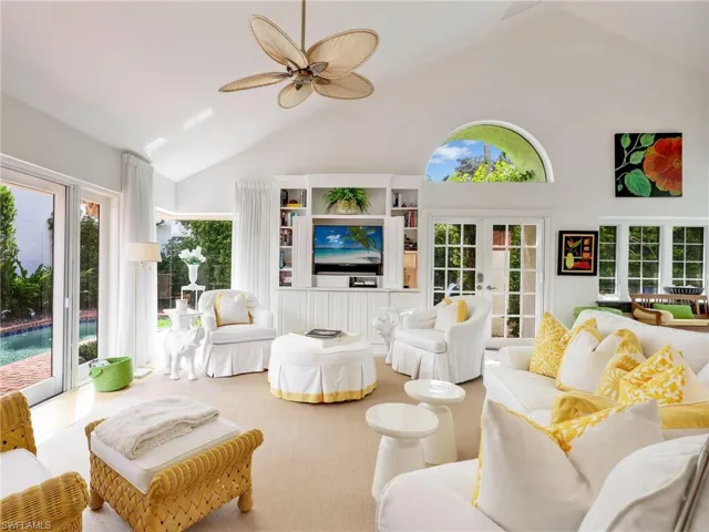 Great Room with Built-In Entertainment Center, French Doors, Arched Window, and Vaulted Ceiling