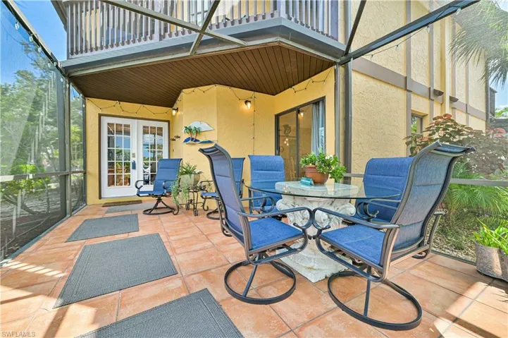 View of patio with outdoor dining area, french doors, and a balcony