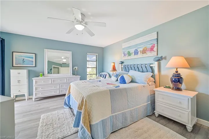 Bedroom with wood finished floors, a ceiling fan, and baseboards
