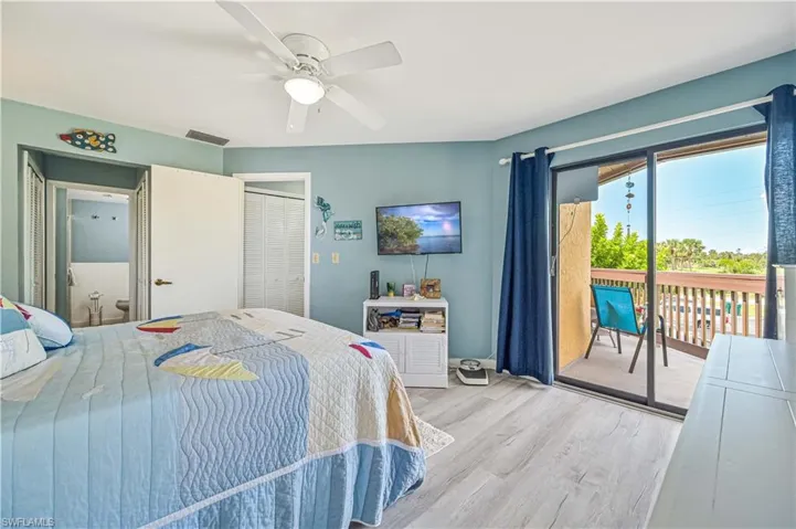 Bedroom with visible vents, a ceiling fan, wood finished floors, access to outside, and a closet