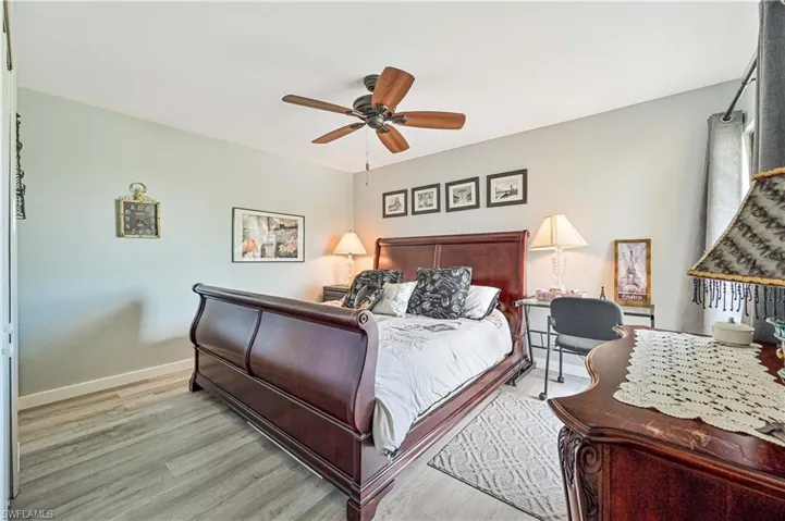 Bedroom featuring wood finished floors, a ceiling fan, and baseboards