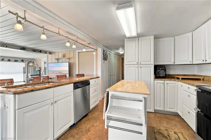 White cabinetry with brushed nickel hardware, stainless steel dishwasher, brown granite-look countertops, wood-finish flooring, and a white beadboard backsplash