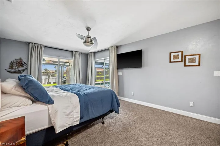 Master Bedroom view with patio doors to pool area and enclosed patio