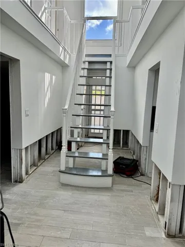 Stairs featuring hardwood / wood-style flooring and a towering ceiling