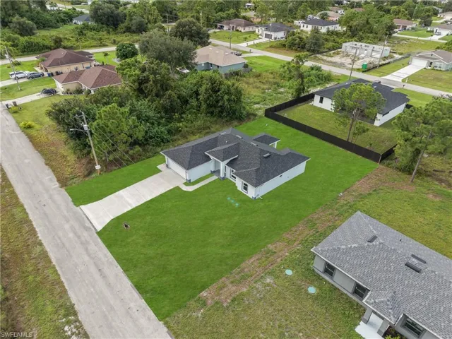 Contemporary single-story residence with light gray exterior siding, dark shingle roof, and a concrete driveway