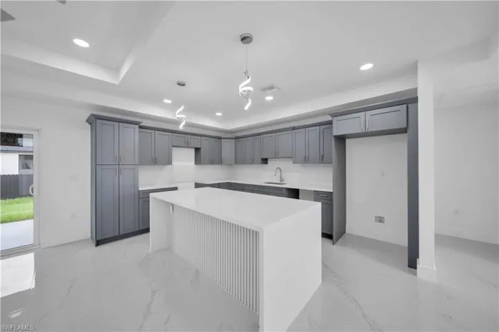 Gourmet kitchen featuring a large central island, gray shaker cabinetry, white countertops, and recessed lighting