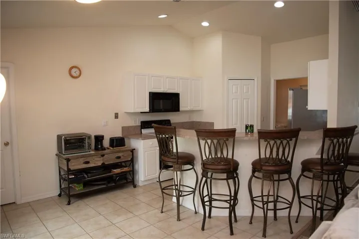 Garage featuring freestanding refrigerator, electric panel, and electric water heater