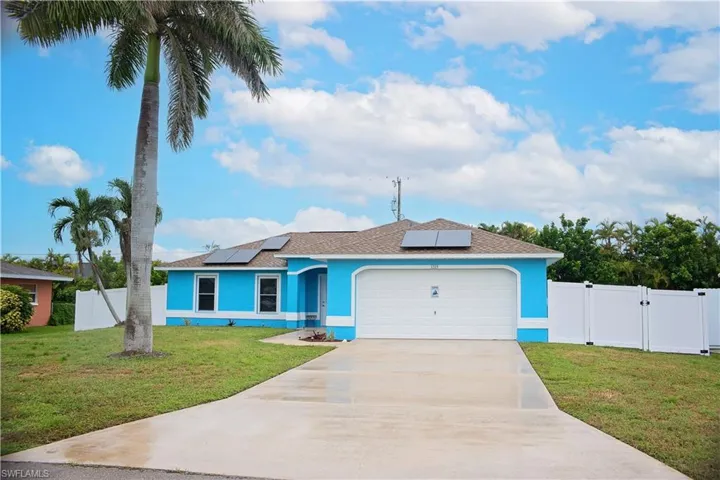 Ranch-style house with roof with shingles, roof mounted solar panels, concrete driveway, and stucco siding