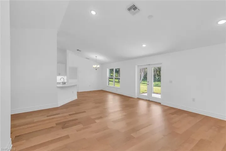 Vaulted living room with view of dining room.  French doors lead to the back covered porch.