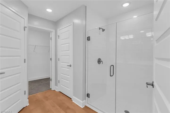 Primary bathroom with large shower and views into the walk in closet, door to water closet.
