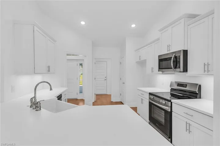 Kitchen looking toward front door to the left, laundry and garage door straight ahead.
