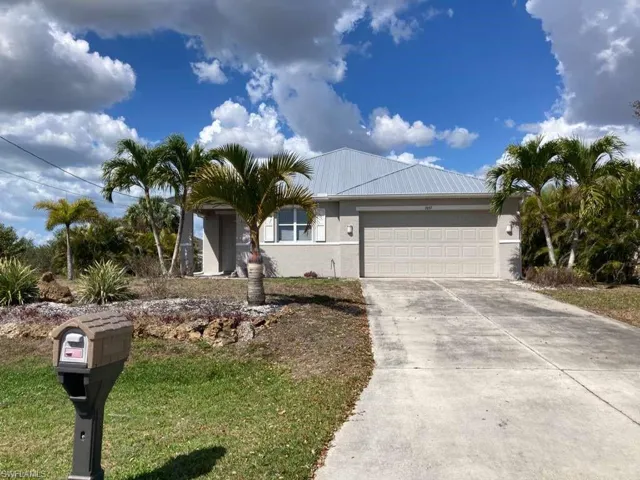 The property features a concrete driveway leading to an attached garage