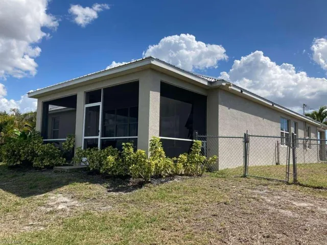 The property features an exterior with stucco siding and a screened-in patio area