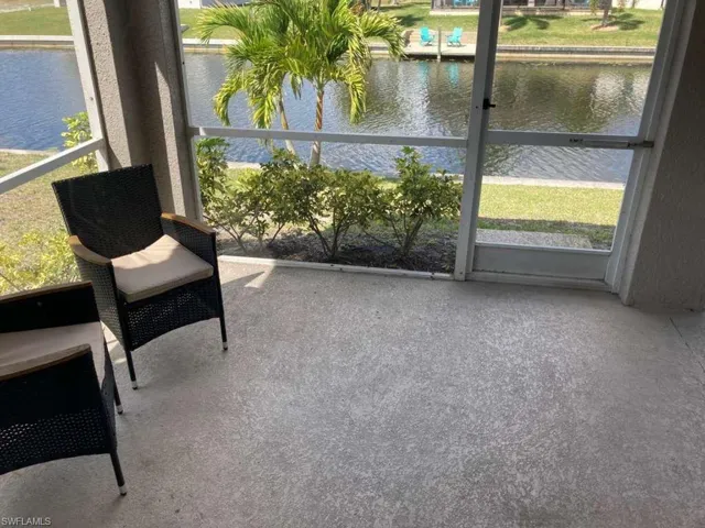 Enjoy waterfront views from the screened patio, featuring a durable concrete floor and lush tropical landscaping