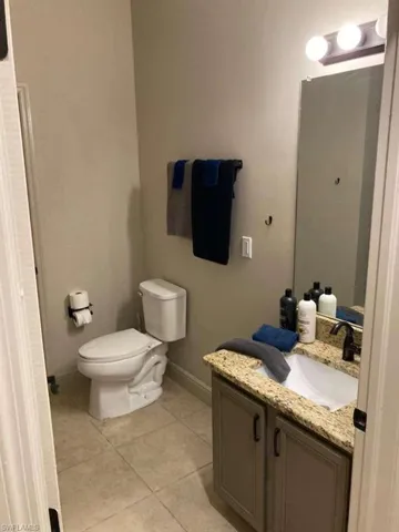Bathroom featuring a vanity with a granite countertop, a rectangular sink, and tile flooring
