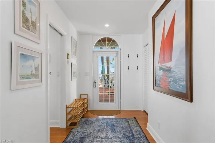 Doorway with wood finished floors and recessed lighting