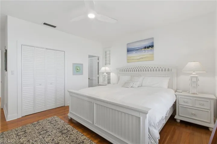 Bedroom featuring dark wood-style flooring, a closet, and ceiling fan