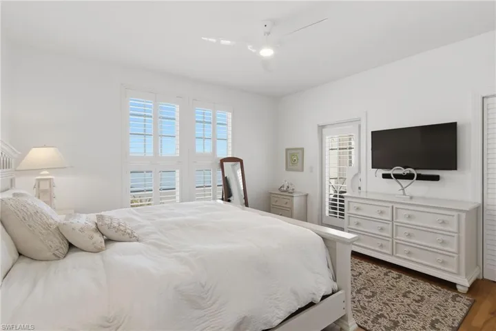 Bedroom with ceiling fan and dark wood-style flooring