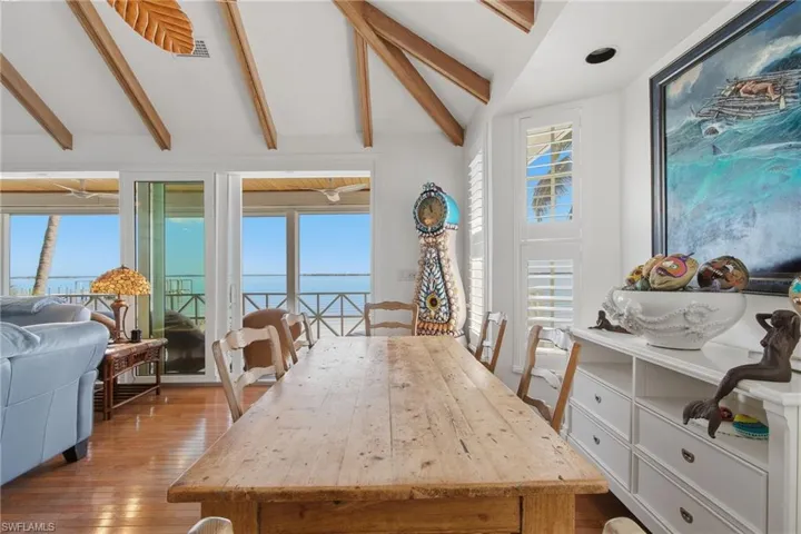 Dining room with healthy amount of natural light, a water view, and light wood-style floors