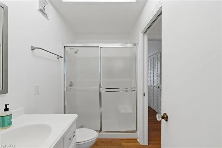 Bathroom featuring vanity, a stall shower, and light wood finished floors