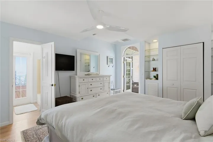 Bedroom with a closet, ceiling fan, and light wood-style floors