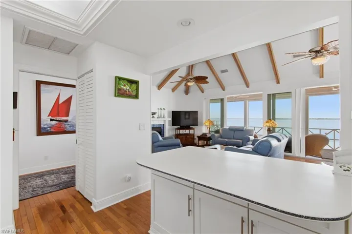 Kitchen with white cabinetry, ceiling fan, light countertops, and light wood-style flooring