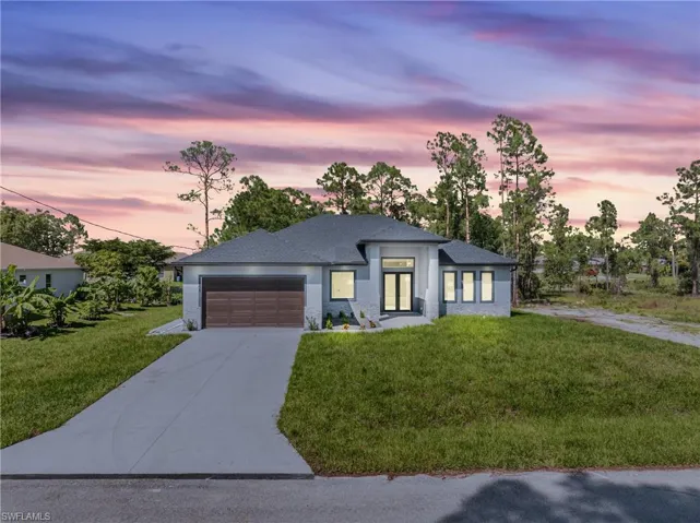 Prairie-style home with a garage and a lawn
