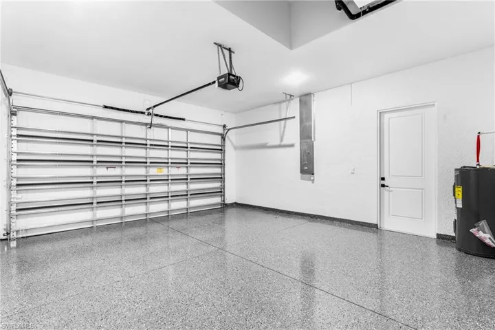 Garage featuring a garage door opener and water heater