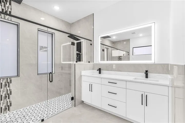 Bathroom with tile walls, vanity, and an enclosed shower