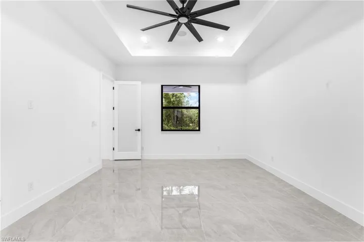 Spare room with a tray ceiling and ceiling fan
