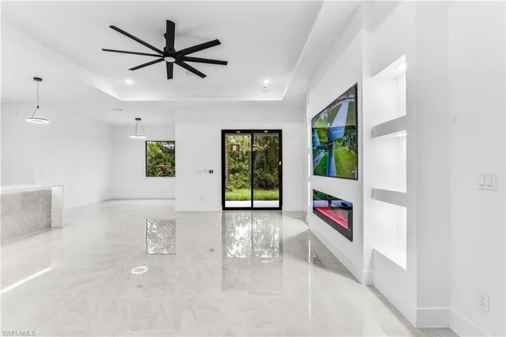Spare room with ceiling fan and a tray ceiling