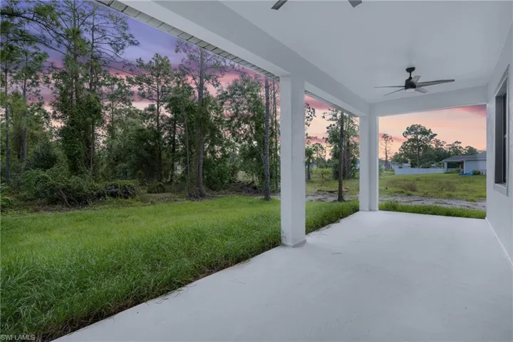Patio terrace at dusk with a lawn and ceiling fan