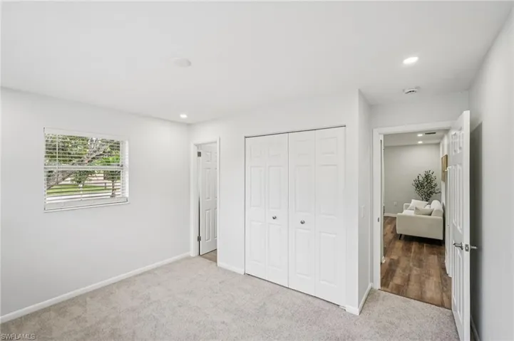 Unfurnished bedroom with carpet flooring, a closet, and recessed lighting