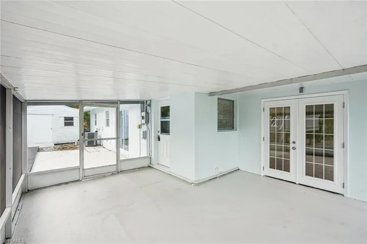 Unfurnished sunroom featuring french doors