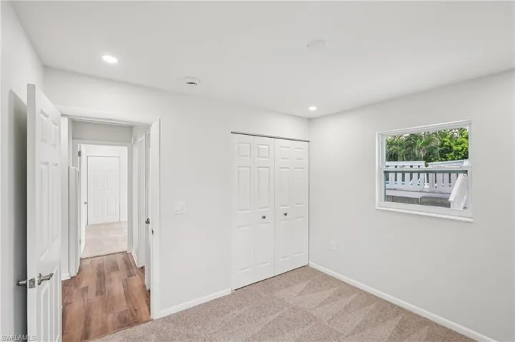 Unfurnished bedroom featuring light colored carpet, recessed lighting, and a closet