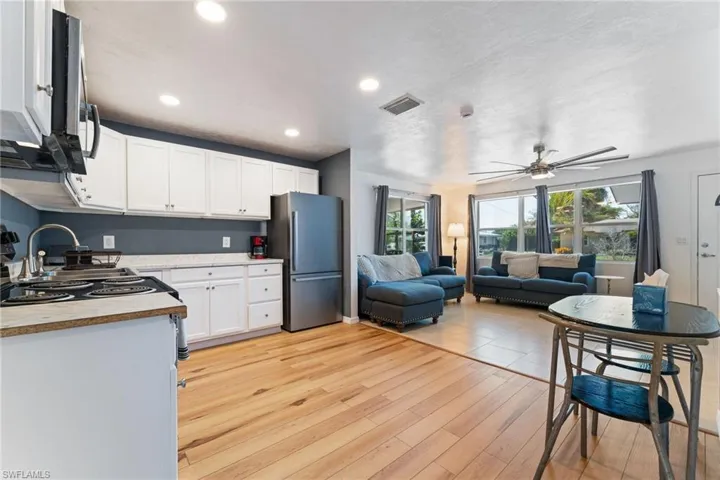 Kitchen featuring stainless steel appliances, light countertops, white cabinets, open floor plan, and recessed lighting