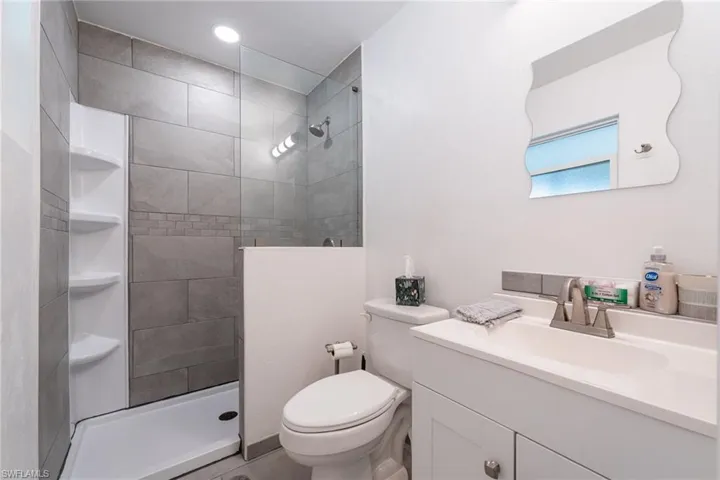 Full bath featuring vanity, a tile shower, and recessed lighting