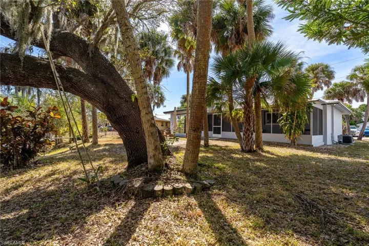 View of grassy yard with a sunroom