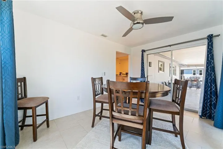Dining space with a ceiling fan and light tile patterned flooring