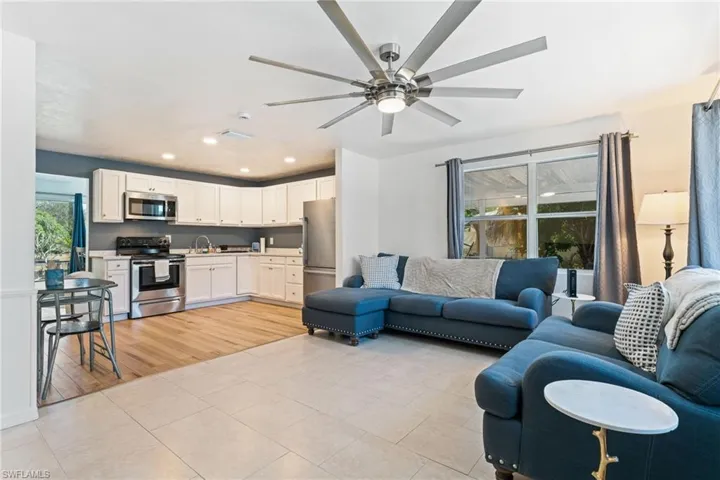 Living area with recessed lighting, light tile patterned floors, and ceiling fan