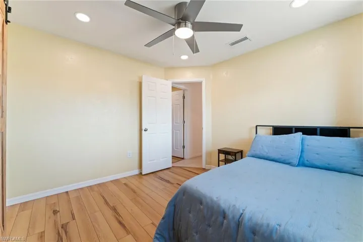 Bedroom with light wood-style floors, recessed lighting, and ceiling fan