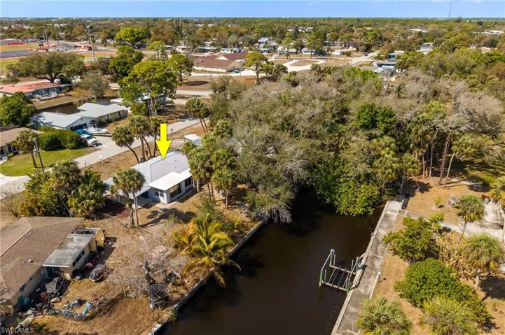 Aerial view of residential area with a large body of water and a tree filled landscape