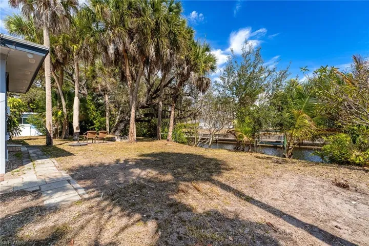 View of yard with a patio, a water view, and a dock