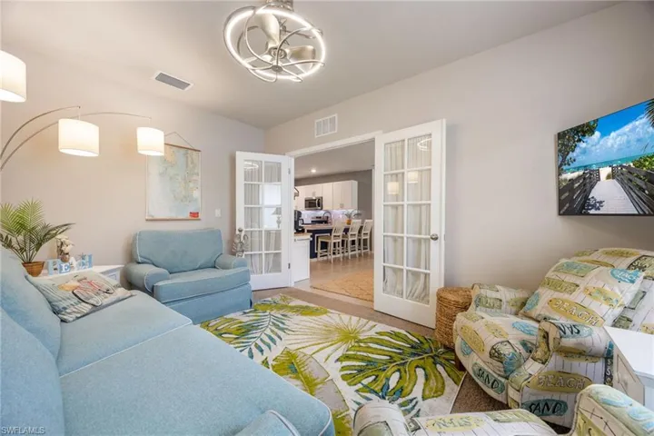 Recessed lighting and a decorative ceiling fan illuminate this interior space featuring light-toned walls